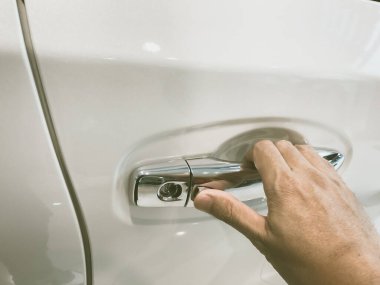 Adamın eli arabanın arka kapısını açıyor.