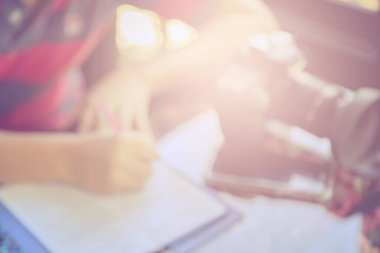 Masa arkasında kamera ve akıllı telefon ile uygulamayı dolduran adamın bulanık görüntüsü