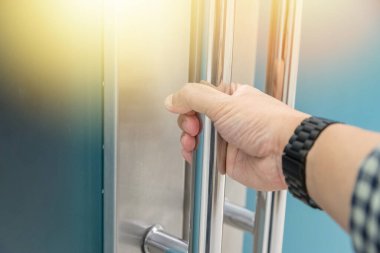 Elle açılan metal, modern ofis kapısı.