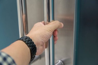 Elle açılan metal, modern ofis kapısı.