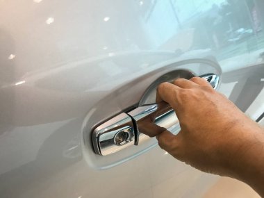 Adamın eli arabanın arka kapısını açıyor.