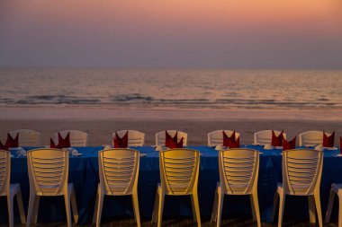 Gün batımında sahilde yemek masası.