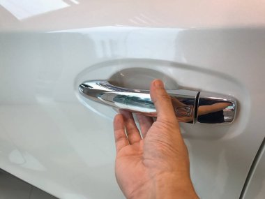 Adamın eli arabanın arka kapısını açıyor.