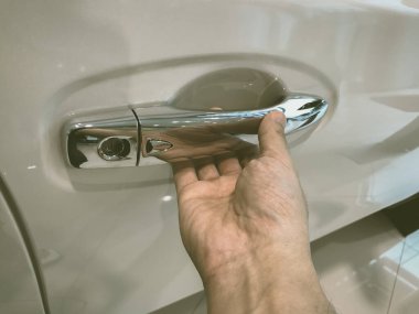 Adamın eli arabanın arka kapısını açıyor.