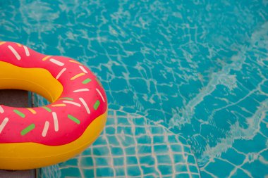 Mavi yüzme havuzu arka planında lastik halka