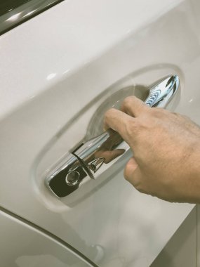 Adamın eli arabanın arka kapısını açıyor.