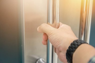 Elle açılan metal, modern ofis kapısı.