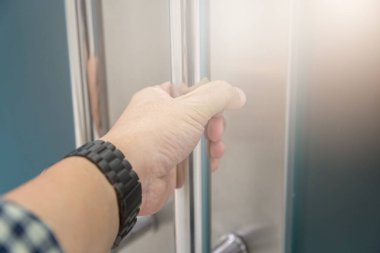 Elle açılan metal, modern ofis kapısı.