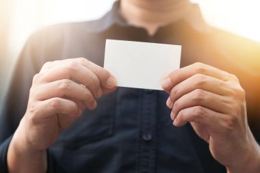Boş beyaz kartviziti olan kendine güvenen bir iş adamı.