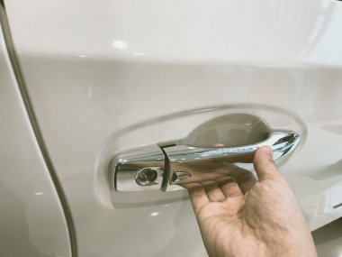 Adamın eli arabanın arka kapısını açıyor.