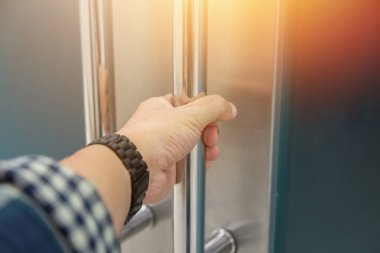 Elle açılan metal, modern ofis kapısı.