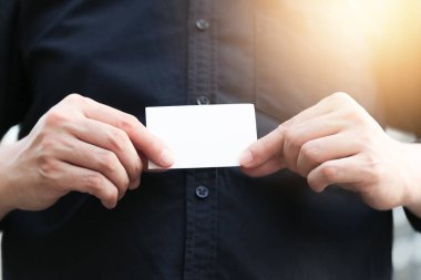Boş beyaz kartviziti olan kendine güvenen bir iş adamı.