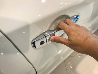 Adamın eli arabanın arka kapısını açıyor.