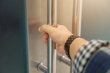 Elle açılan metal, modern ofis kapısı.