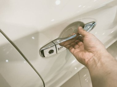 Adamın eli arabanın arka kapısını açıyor.