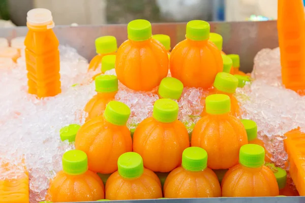 冷たいオレンジジュースは 氷の背景とさわやかなために飲む準備ができてボトルに — ストック写真