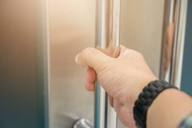 Elle açılan metal, modern ofis kapısı.