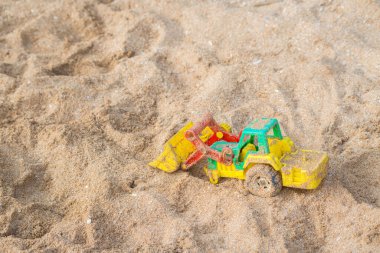 Kumsal arka planında renkli oyuncak araba