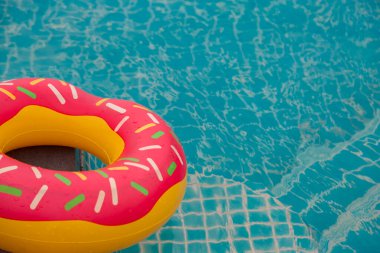 Mavi yüzme havuzu arka planında lastik halka