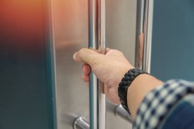 Elle açılan metal, modern ofis kapısı.