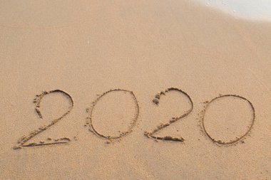 2020 yılında plaj kumları üzerine yazılmış soyut bir mesaj.
