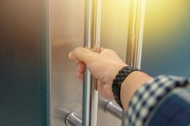 Elle açılan metal, modern ofis kapısı.