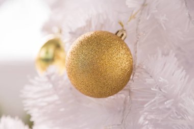 Beyaz Noel Ağacı arkaplanındaki Altın Top