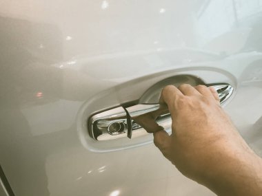 Adamın eli arabanın arka kapısını açıyor.