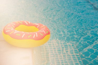 Mavi yüzme havuzu arka planında lastik halka