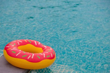 Mavi yüzme havuzu arka planında lastik halka