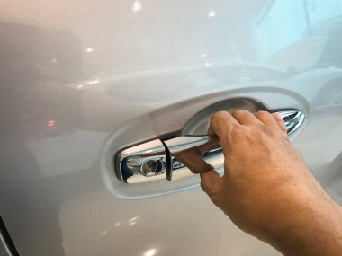 Adamın eli arabanın arka kapısını açıyor.