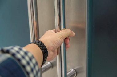 Elle açılan metal, modern ofis kapısı.