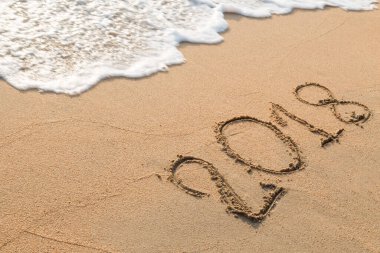 2018 plaj arka planındaki kuma yazılmış bir mesaj.