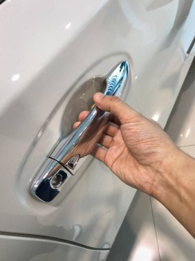 Adamın eli arabanın arka kapısını açıyor.