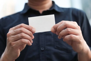 Boş beyaz kartviziti olan kendine güvenen bir iş adamı.