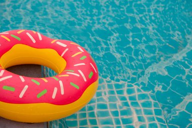 Mavi yüzme havuzu arka planında lastik halka