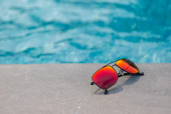 游泳池背景附近的时髦太阳镜 — 图库照片