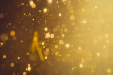 Siyah arkaplanda koyu soyut altın bokeh parıltısı