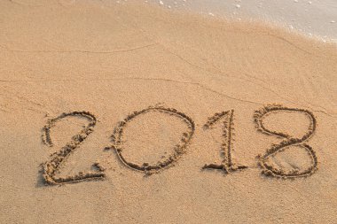 2018 plaj arka planındaki kuma yazılmış bir mesaj.