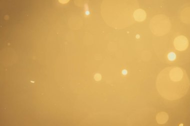 Siyah arkaplanda koyu soyut altın bokeh parıltısı