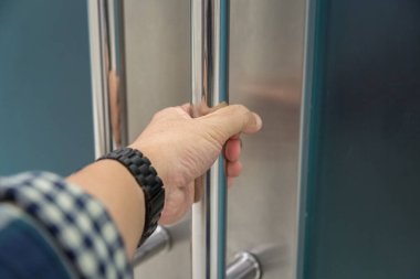 Elle açılan metal, modern ofis kapısı.