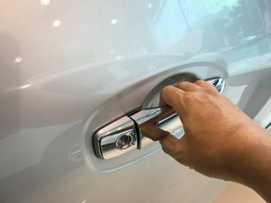 Adamın eli arabanın arka kapısını açıyor.