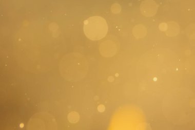 Siyah arkaplanda koyu soyut altın bokeh parıltısı