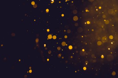 Siyah arkaplanda koyu soyut altın bokeh parıltısı
