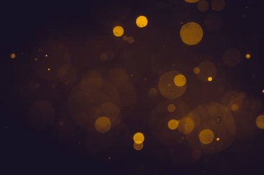 Siyah arkaplanda koyu soyut altın bokeh parıltısı