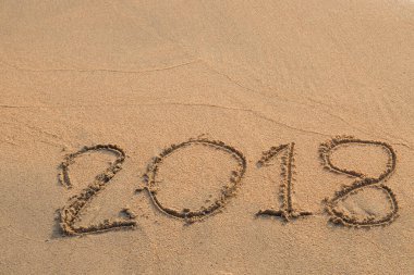 2018 plaj arka planındaki kuma yazılmış bir mesaj.