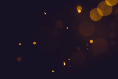 Siyah arkaplanda koyu soyut altın bokeh parıltısı