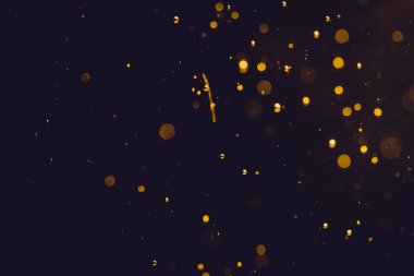 Siyah arkaplanda koyu soyut altın bokeh parıltısı