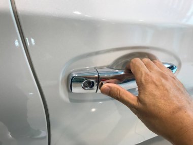 Adamın eli arabanın arka kapısını açıyor.