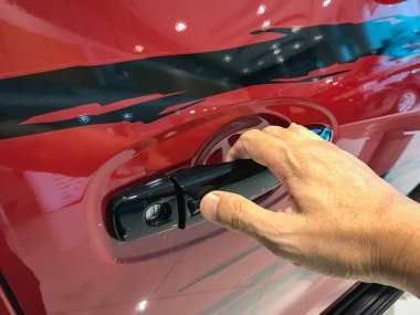 Adamın eli arabanın arka kapısını açıyor.